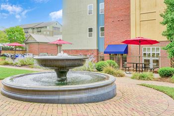 A fountain in the middle of a brick walkway at The Lofts at Reynolds Village Apartments, Asheville, NC